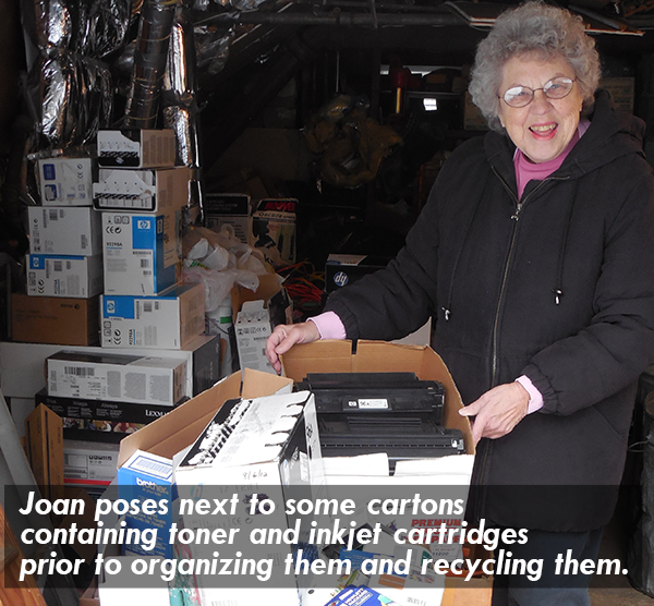 image of Joan posing next to some cartons containing toner and inkjet cartridges prior to organizing them and recycling them.